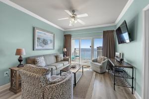 sala de estar con sofá, sillas y TV en Crystal Tower Unit 908, en Gulf Shores