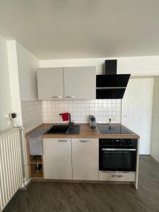 een keuken met witte kasten en een wastafel bij Wohnung Rhein-Wald-und Weitsicht in Rengsdorf