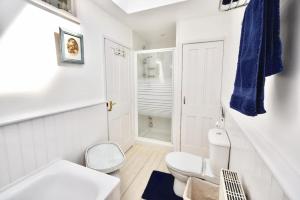 een witte badkamer met een toilet en een wastafel bij Mulberry Cottage in Cowes +15 foto's