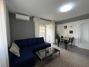 a living room with a blue couch and a table at Roger Balcon Mediterraneo Tarragona in Tarragona