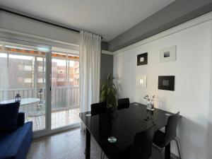 sala de estar con mesa y ventana grande en Roger Balcon Mediterraneo Tarragona en Tarragona