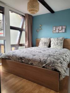 a bed in a bedroom with a blue wall at L'Appart avec terrasse - centre historique in Barr