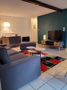 a living room with a couch and a flat screen tv at L'Appart avec terrasse - centre historique in Barr