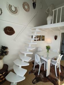 une salle à manger blanche avec une table et des chaises blanches dans l'établissement Résidence de Charme TIVOLI, à Arcachon