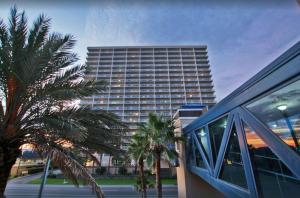 a tall building with palm trees in front of a building at Crystal Tower Unit 908 in Gulf Shores