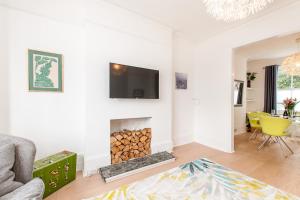 a living room with a fireplace and a tv on the wall at Seaside Retreat W Garden - Beach Hut Hire in Broadstairs