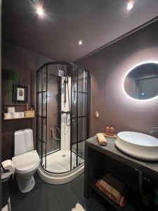 a bathroom with a shower and a toilet and a sink at Drømmefabrikken in Bleik +23 photos