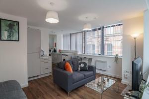 a living room with a couch and a glass table at Modern Studio Apartment in Central Liverpool in Liverpool