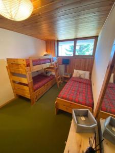 a room with two bunk beds and a table at Residence “I Larici” Folgarida in Folgarida