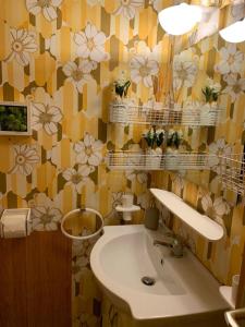 a bathroom with a sink and flowers on the wall at Residence “I Larici” Folgarida in Folgarida