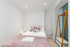 a bedroom with a bed with two towels on it at Seaside Retreat W Garden - Beach Hut Hire in Broadstairs