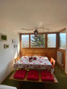 a dining room with a table and red cushioned chairs at Residence “I Larici” Folgarida in Folgarida