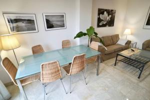 un soggiorno con tavolo e sedie blu di El Balcón del Novo -Novo Sancti Petri- Luxury 3 Bedrooms - Piscina y Pista Padel a Chiclana de la Frontera