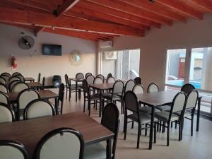 a dining room with tables and chairs and windows at DEL SOL APART TERMAL II in Termas de Río Hondo