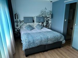 - une chambre avec un lit dans une pièce bleue dans l'établissement Palace Hotel Zandvoort, à Zandvoort