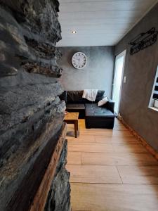 a living room with a stone wall and a couch at La Ptit Marie in Houffalize