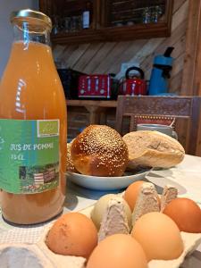 a bottle of orange juice next to eggs and bread at La Ptit Marie in Houffalize