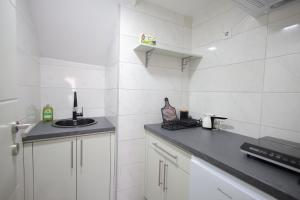 a white kitchen with a sink and a counter at Soho 1 in Vrnjačka Banja