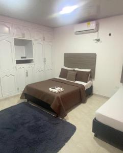リオアチャにあるHotel la Sierra Riohacha IIのベッドルーム1室(大型ベッド1台、青いラグ付)