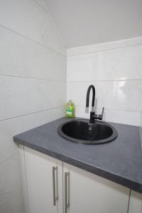 a bathroom sink with a black counter top at Soho 1 in Vrnjačka Banja