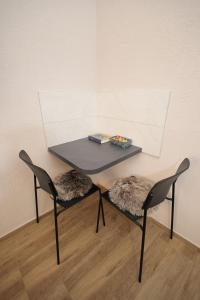 Vrnjačka Banja的住宿－Soho 1，一张桌子,两把椅子,一张桌子,一张桌子,上面放着一盘食物