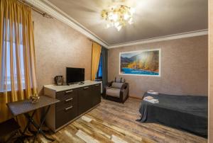 a bedroom with a bed and a chair and a television at Aurora Villas in Dilijan
