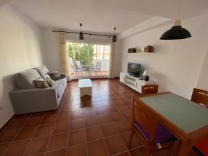 - un salon avec un canapé et une table dans l'établissement Adosados Palm Beach Altamar, à Alcossebre