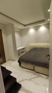 een slaapkamer met een bed in een kamer met marmeren vloeren bij The unit beside historical elevator in Konak