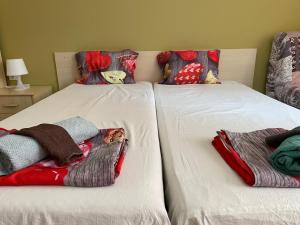 two beds with blankets and pillows on them at Comfort Apartment in Pomorie