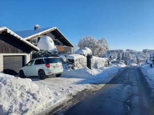 een auto geparkeerd aan de kant van een weg bedekt met sneeuw bij Harzhaus Rauch in Braunlage +9 foto's