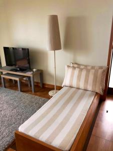 una camera da letto con un letto con una lampada e una TV di One bedroom house with sea view enclosed garden and wifi at Moledo a Moledo