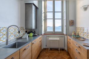 a kitchen with a sink and a large window at Villa Selva Luxury Lakeview Apartment in Ghiffa