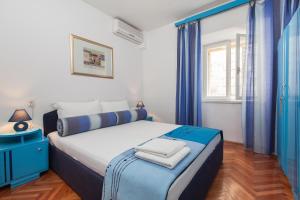 Schlafzimmer mit einem großen Bett und blauen Vorhängen in der Unterkunft Apartments Potts Point in Makarska
