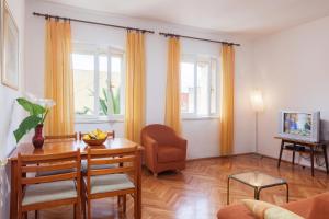 ein Wohnzimmer mit einem Tisch und einem Stuhl in der Unterkunft Apartments Potts Point in Makarska