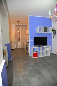 ein Wohnzimmer mit einem TV und einer blauen Wand in der Unterkunft Civico 93 C in Battipaglia
