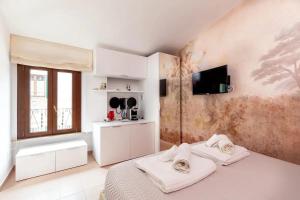a bedroom with two beds and a tv on the wall at L'inchiostro di Dante in Macerata