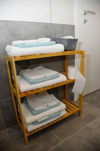 ein Holzregal mit Handtüchern im Bad in der Unterkunft Civico 93 C in Battipaglia