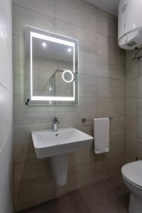 a bathroom with a sink and a mirror and a toilet at Gospa 58 - 1 bedroom apt in Birżebbuġa