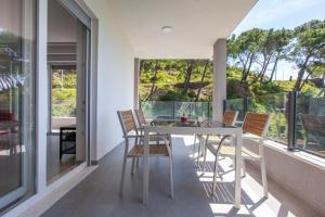 a dining room with a table and chairs on a balcony at Apartment URSA in Podgora