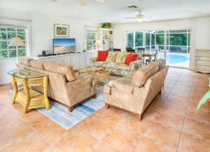 a living room with two couches and a table at Baywatch Cottage in Captiva