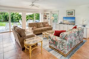 - un salon avec deux canapés et une table dans l'établissement Baywatch Cottage home, à Captiva