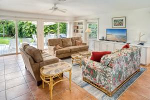 a living room with two couches and a table at Baywatch Cottage in Captiva