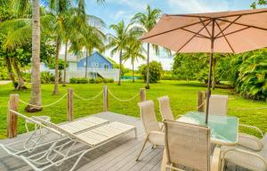 a patio with a table and chairs and an umbrella at Baywatch Cottage in Captiva