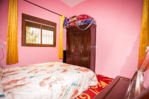 a bedroom with a bed and a wooden cabinet at La belle vue in Daher