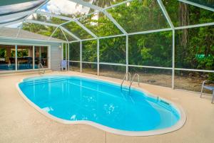 a swimming pool in a house with a large building at Baywatch Cottage in Captiva