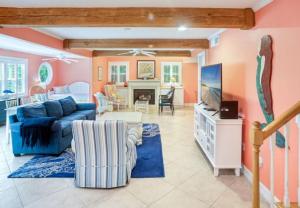 a living room with a blue couch and a tv at Lollipop home in Captiva