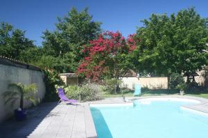 a swimming pool with two lawn chairs and a tree at Le Clos de la Salamandre in Duravel