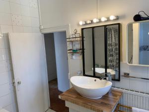 Un baño con un lavabo blanco y un espejo. en Porte de Paris, en Montesson 33 fotos más