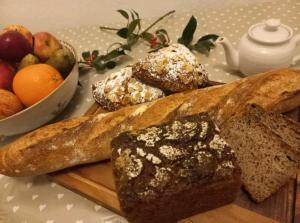 una mesa cubierta con pan y un bol de fruta en Gelly Dylan Thomas Paradise, en Lampeter