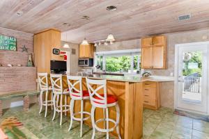 a kitchen with a bar with stools in it at Baybarlyn home in Captiva